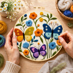Creating the three whimsical butterflies among flowers wool painting by hand with a felting needle