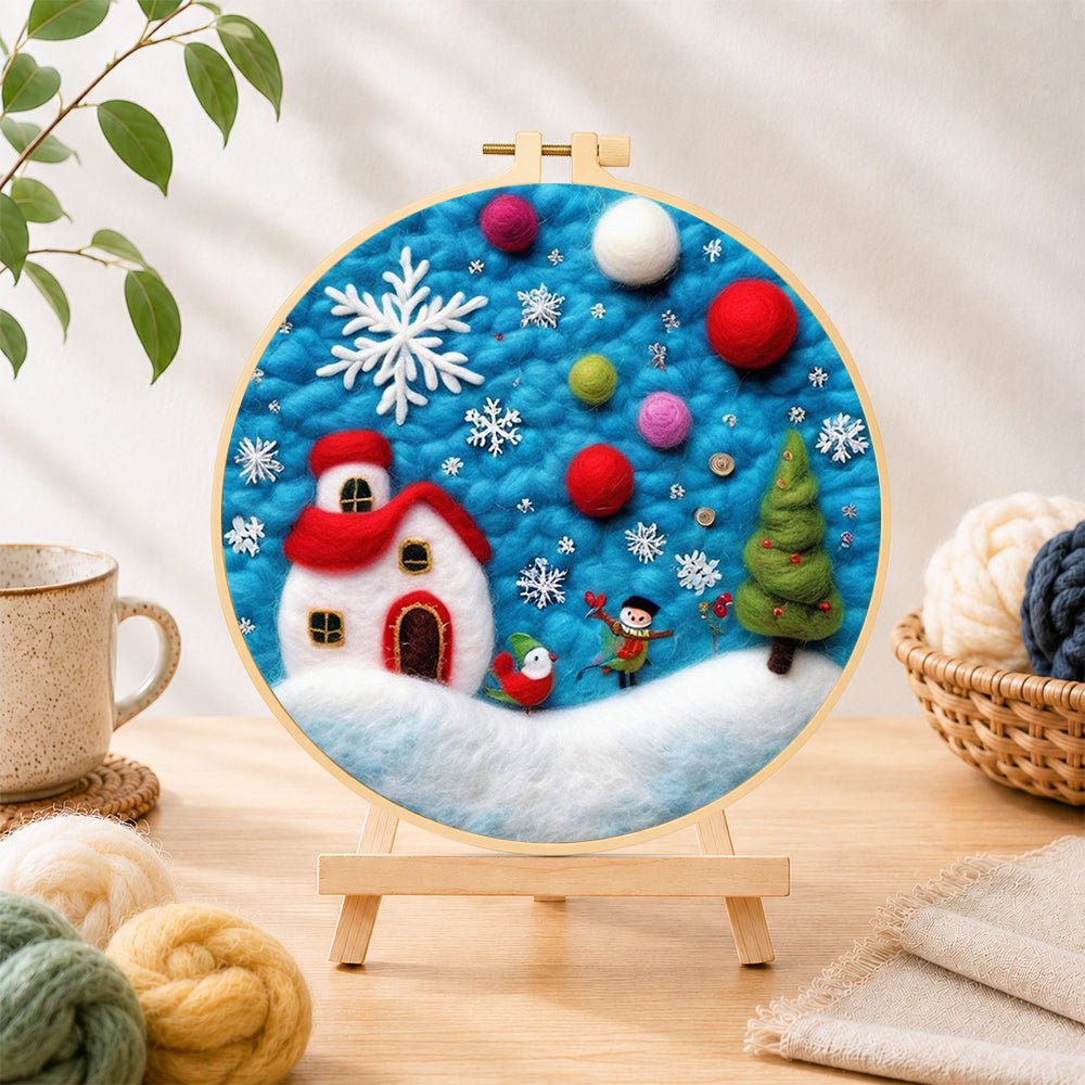 Finished tiny scene with red house and snowflake needle felting displayed on a wooden easel