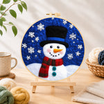 Finished top hat snowman with falling snowflakes needle felting displayed on a wooden easel