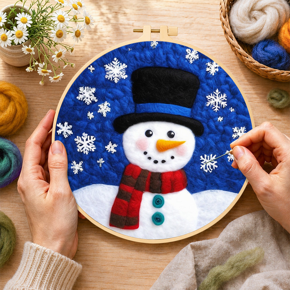 Creating the top hat snowman with falling snowflakes wool painting by hand with a felting needle