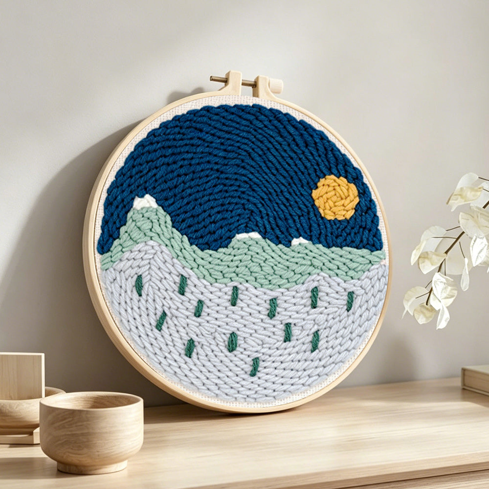Tranquil mountain scenery punch needle artwork displayed on a table
