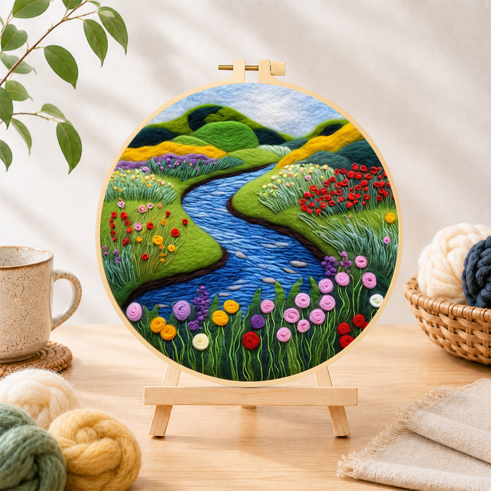 Finished tranquil river, wildflowers and meadow needle felting displayed on a wooden easel