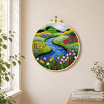 Tranquil river, wildflowers and meadow needle felt wall art displayed in a bright home interior