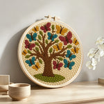 Tree of life with colourful butterflies punch needle artwork displayed on a table