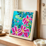 Tropical lily flowers and hummingbird punch needle artwork displayed on a table
