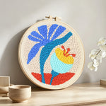 Tropical plant and flower punch needle artwork displayed on a table