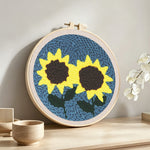 Two bright sunflowers punch needle artwork displayed on a table