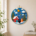 Two christmas cats with red house needle felt wall art displayed in a bright home interior