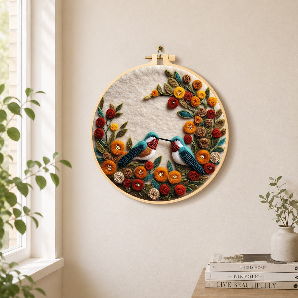 Two hummingbirds with romantic floral wreath needle felt wall art displayed in a bright home interior