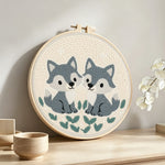 Two little grey foxes punch needle artwork displayed on a table