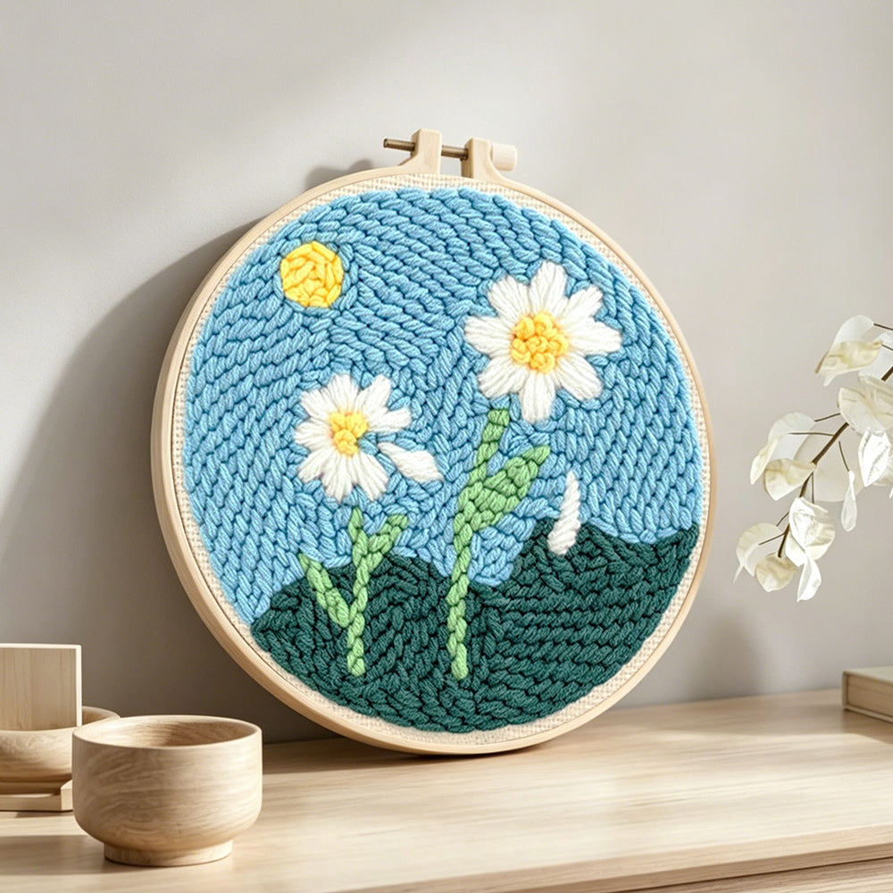 Two pure daisies punch needle artwork displayed on a table