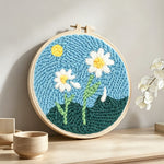 Two pure daisies punch needle artwork displayed on a table