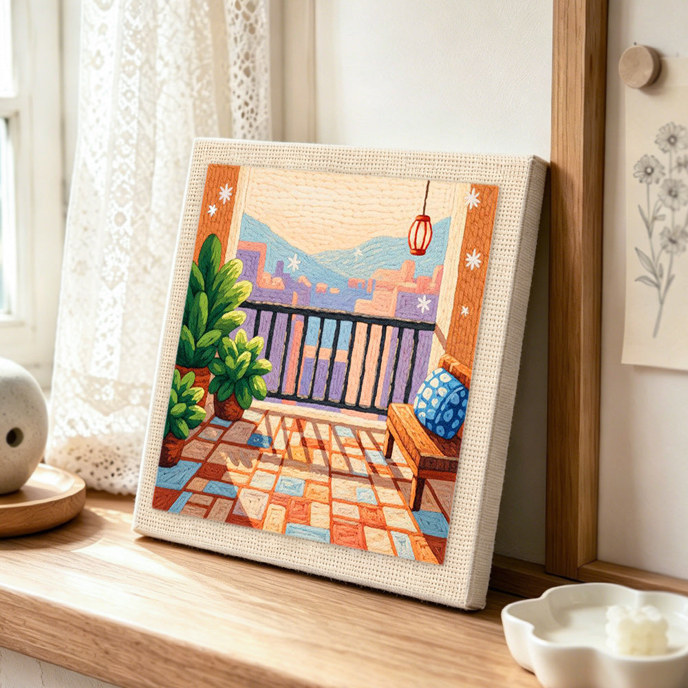 Urban balcony and potted plants punch needle artwork displayed on a table