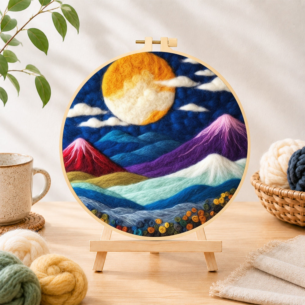 Finished vibrant full moon over mystical peaks needle felting displayed on a wooden easel