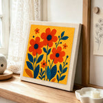Vibrant orange florals punch needle artwork displayed on a table