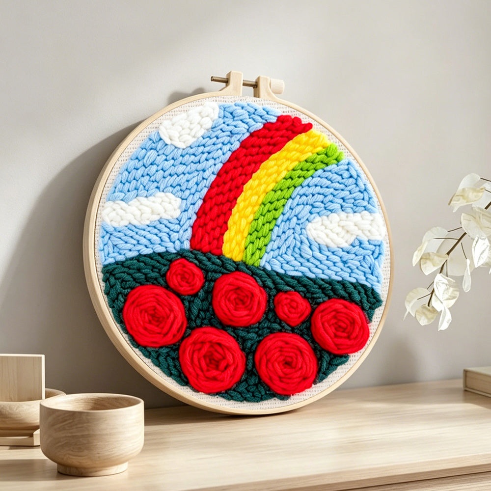 Vibrant rainbow with red roses punch needle artwork displayed on a table