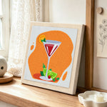 Vibrant red cocktail with lime punch needle artwork displayed on a table