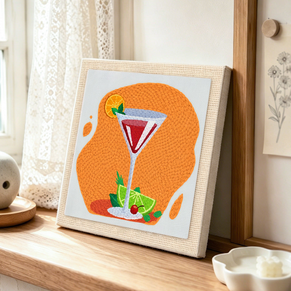 Vibrant red cocktail with lime punch needle artwork displayed on a table