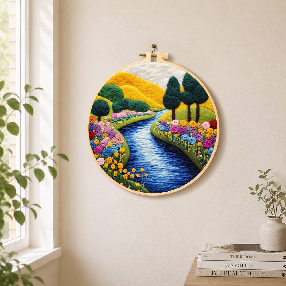 Vibrant rolling hills, sunny river and rainbow flowers needle felt wall art displayed in a bright home interior