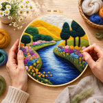 Creating the vibrant rolling hills, sunny river and rainbow flowers wool painting by hand with a felting needle