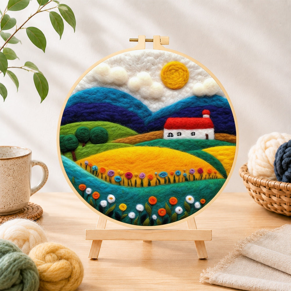 Finished vibrant rural fields needle felting displayed on a wooden easel