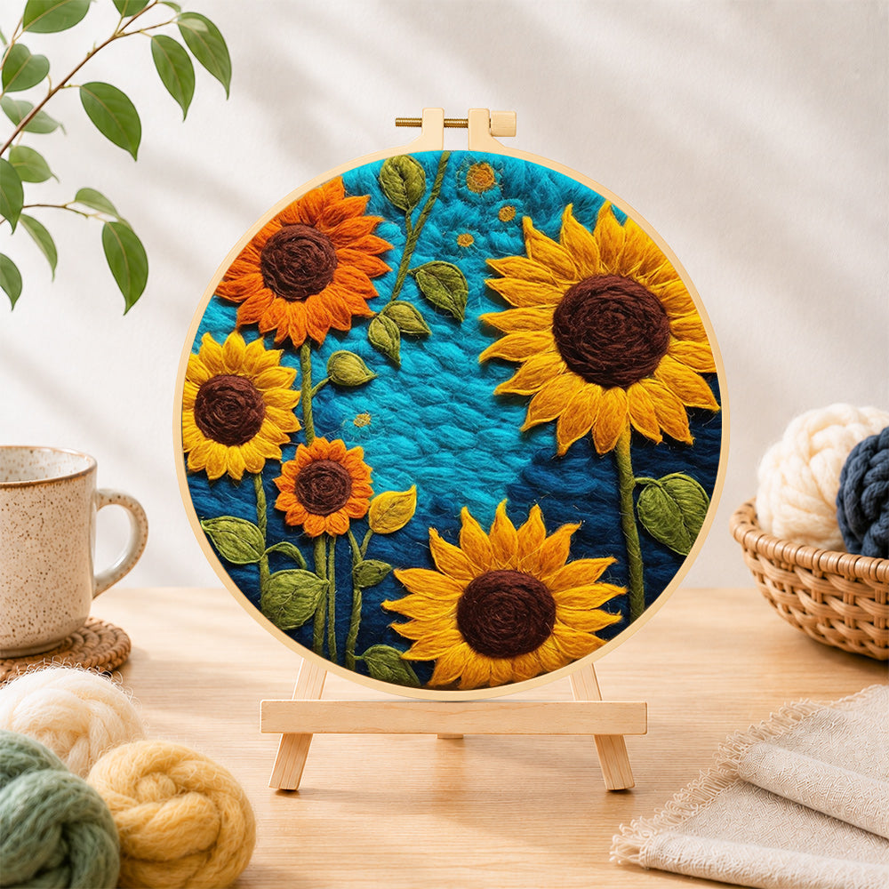 Finished vibrant sunflowers on blue needle felting displayed on a wooden easel