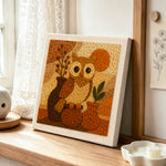 Vintage style owl with vases punch needle artwork displayed on a table