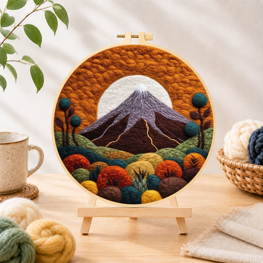 Finished volcanic mountain under the golden sun needle felting displayed on a wooden easel
