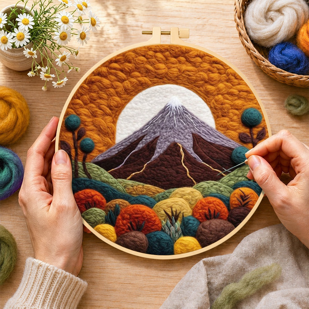 Creating the volcanic mountain under the golden sun wool painting by hand with a felting needle