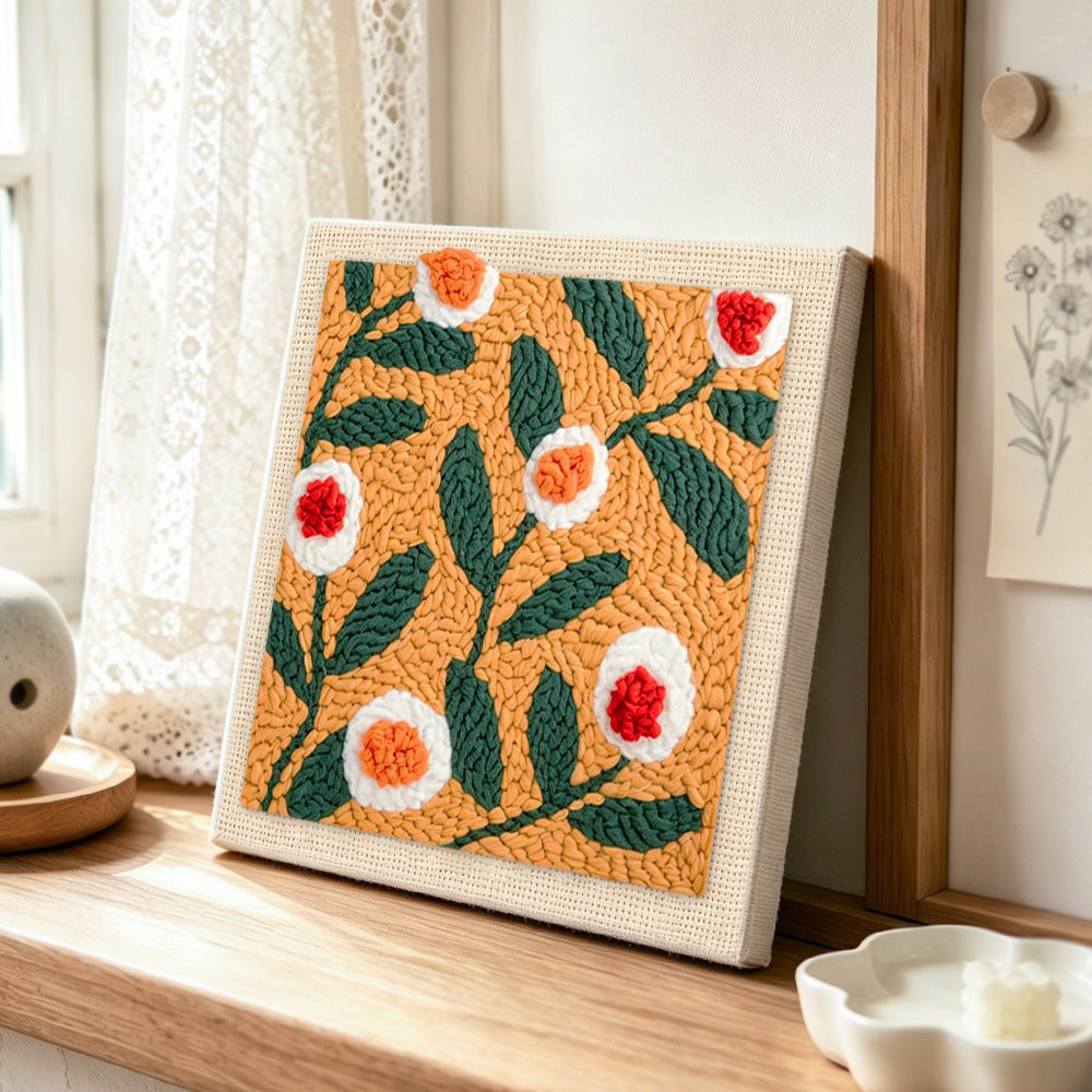 Warm apricot floral punch needle artwork displayed on a table