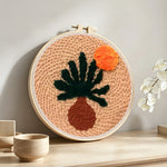 Warm boho desert plant punch needle artwork displayed on a table