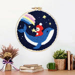 Finished whale and astronaut in starry night sky artwork displayed on a wall