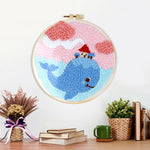Finished whale carrying a small house in dreamy sky artwork displayed on a wall