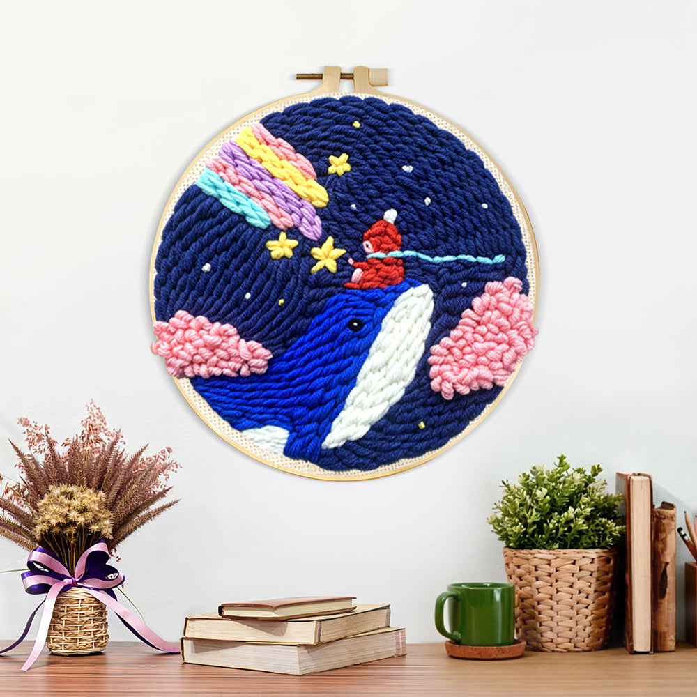 Finished whale in night sky with rainbow and clouds artwork displayed on a wall