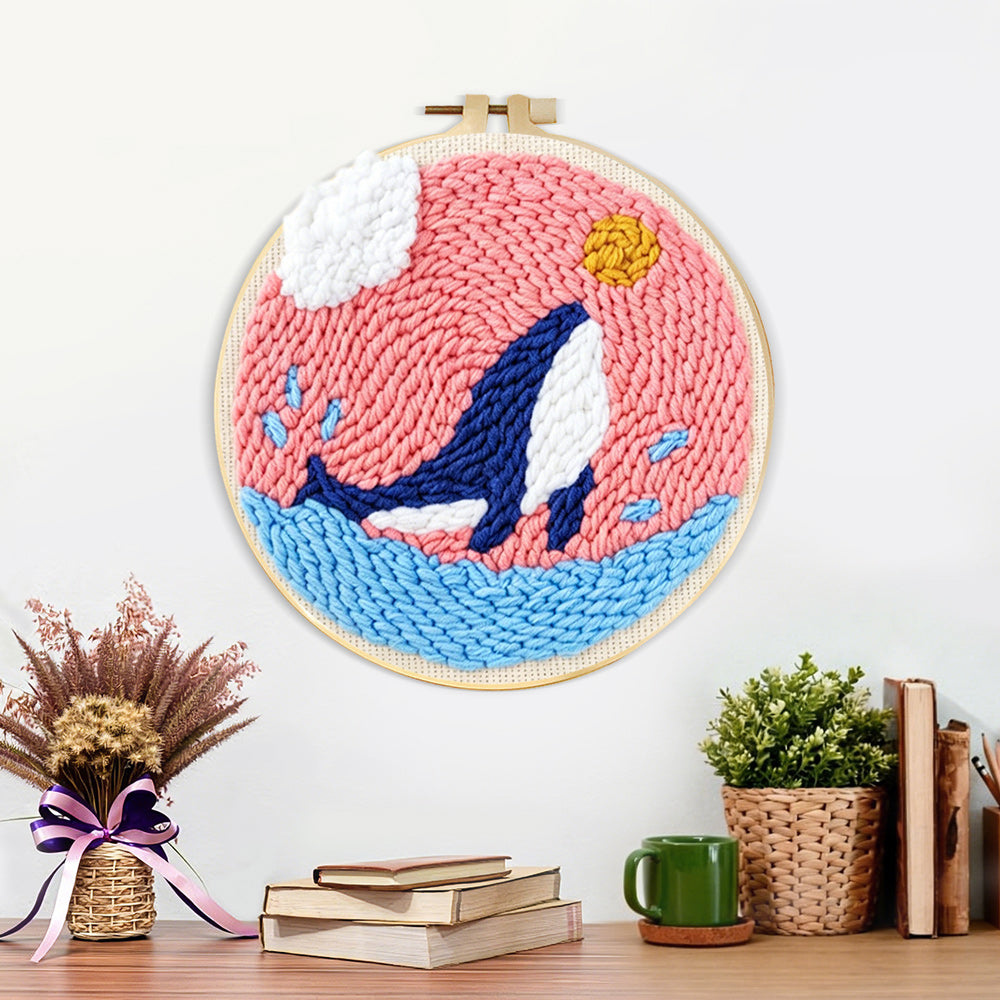 Finished whale jumping in pink sky artwork displayed on a wall
