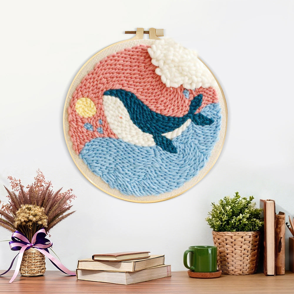 Finished whale jumping out of ocean in pink sky artwork displayed on a wall