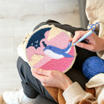 Creating handmade whale jumping out of pink ocean punch needle artwork