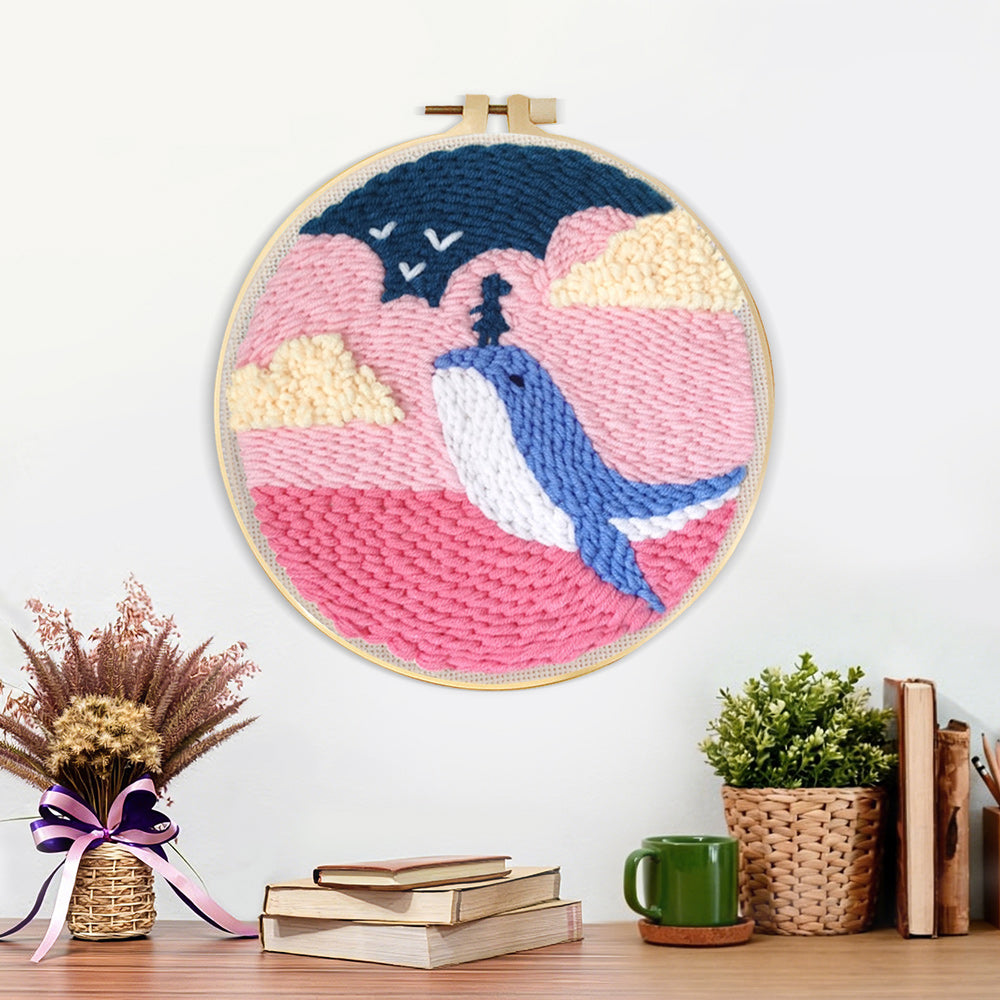 Finished whale jumping out of pink ocean artwork displayed on a wall