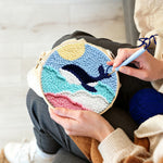 Creating handmade whale jumping over rainbow waves punch needle artwork