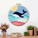Finished whale jumping over rainbow waves artwork displayed on a wall