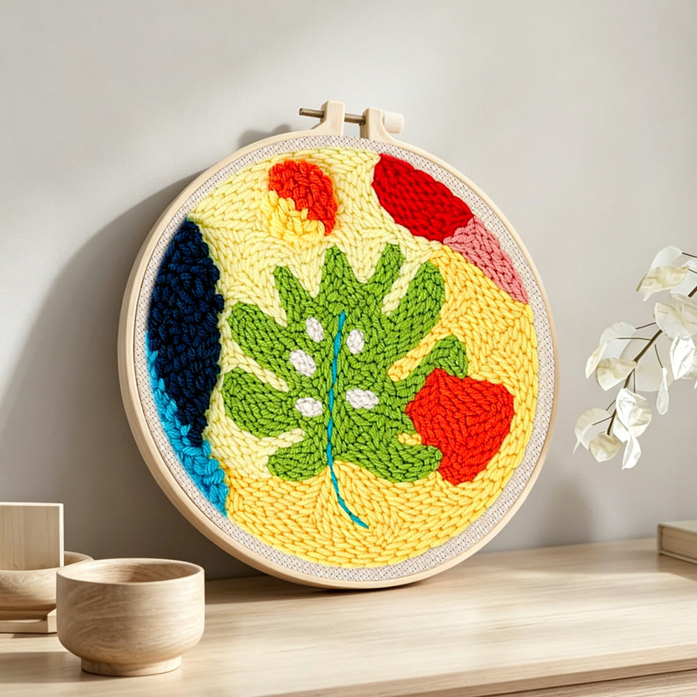 Whimsical abstract leaves punch needle artwork displayed on a table
