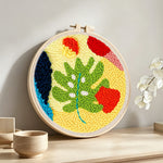 Whimsical abstract leaves punch needle artwork displayed on a table