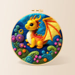 Whimsical baby dragon and colourful spiral plant needle felting kit for beginners with a round wooden frame