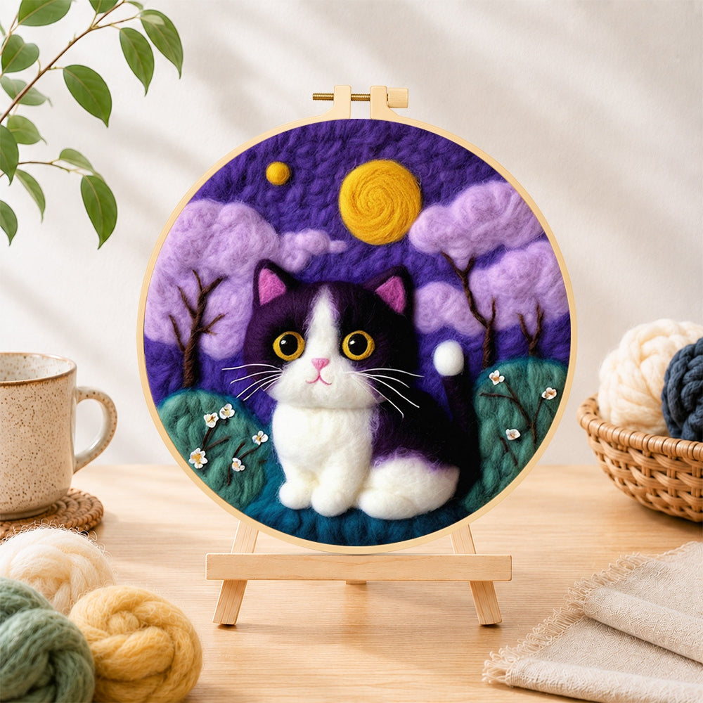 Finished whimsical cat under the purple night sky needle felting displayed on a wooden easel