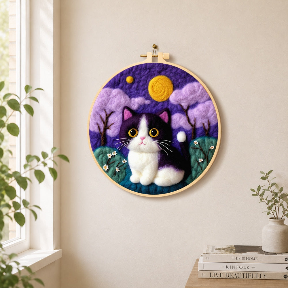 Whimsical cat under the purple night sky needle felt wall art displayed in a bright home interior
