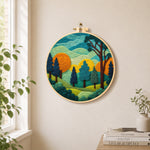 whimsical forest and rolling mountains needle felt wall art displayed in a bright home interior