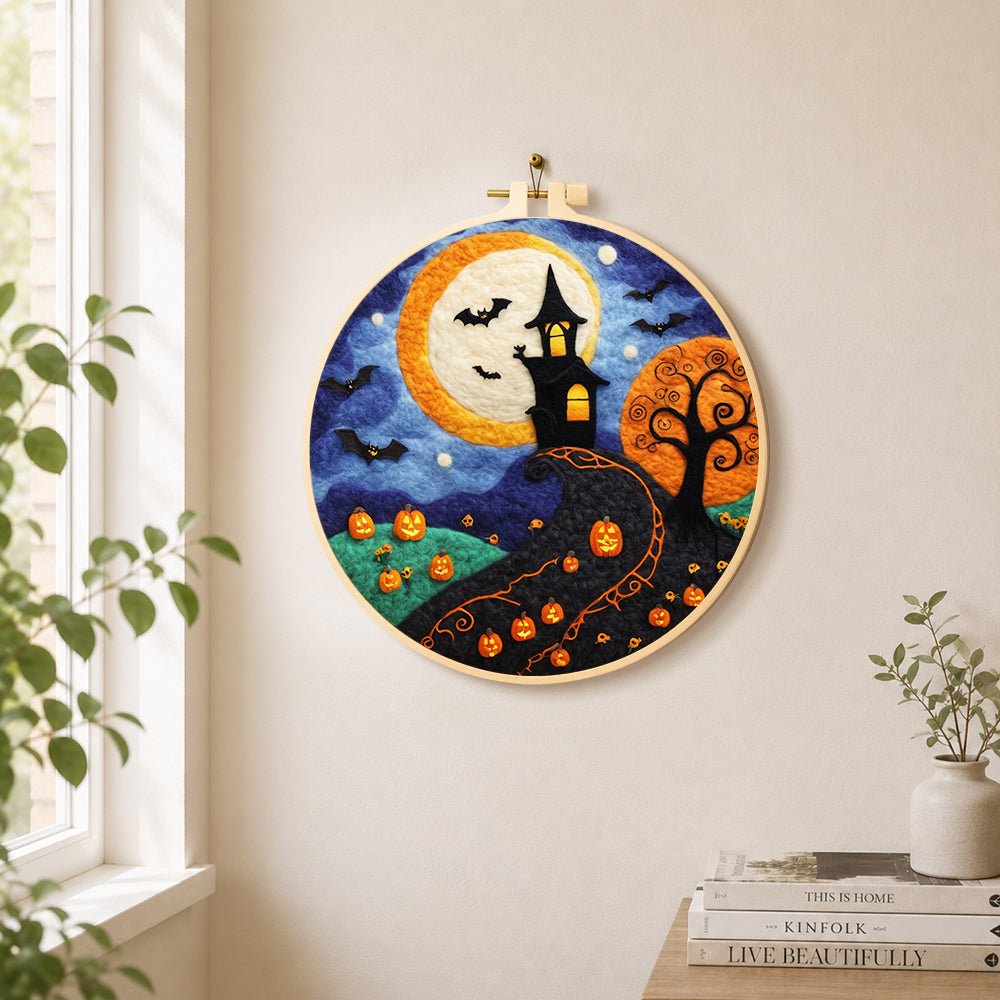 Whimsical haunted village and halloween pumpkins needle felt wall art displayed in a bright home interior