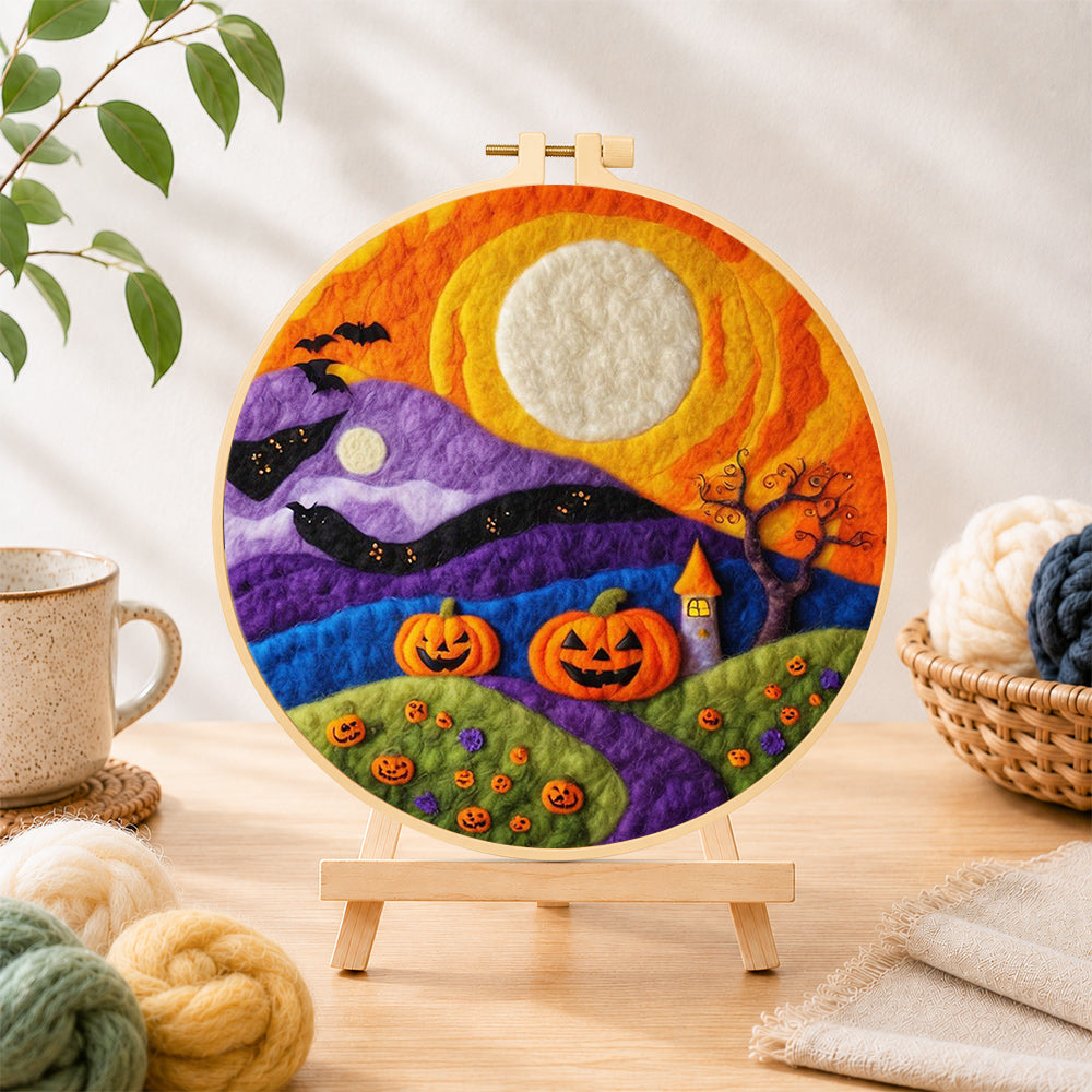 Finished whimsical mountains and moon needle felting displayed on a wooden easel