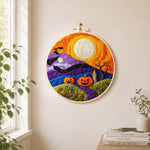 Whimsical mountains and moon needle felt wall art displayed in a bright home interior