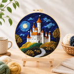 Finished whimsical white castle and blue moon needle felting displayed on a wooden easel